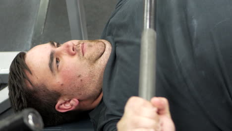 CLOSE-UP-of-a-man-performing-a-bench-press-set-during-a-weight-training-session