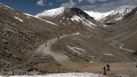 Jóvenes-Montando-En-Bicicleta-En-El-Terreno-Montañoso-De-La-Región-De-Leh-Ladakh-Con-Automóviles-Y-Otros-Vehículos-Detrás
