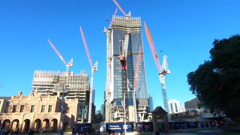 Parramatta-Square-under-construction-showing-cranes-and-one-building-almost-complete-pedestrians-walking-along-mall-in-front-of-building-site-hyperlapse