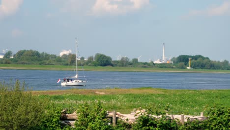 A-dutch-landscapen-with-a-river-and-an-sealship-in-the-front
