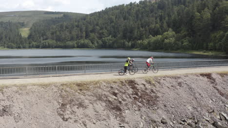 Tres-Ciclistas-De-Montaña-A-Partir-De-La-Pared-De-La-Presa-De-Lac-D&#39;altenweiher-En-Los-Vosgos-Franceses
