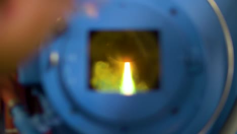 Man-watching-through-the-window-of-plasma-arc-furnace-melting-metal