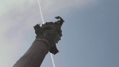 Estatua-De-Cristobal-Colón-Con-Un-Gran-Fondo-De-Cielo-Azul-Y-Rastro-De-Nubes-Desde-Un-Avión-En-Barcelona