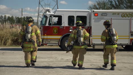 Group-of-firefighters-walk-towards-a-fire-engine-after-responding-to-a-fire-emergency