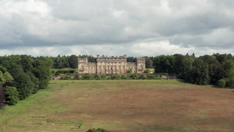 Aerial-Dolly-Shot-of-Harewood-House,-a-Country-House-in-West-Yorkshire,-with-a-Narrow-Crop