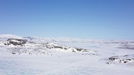 Luftaufnahme-Eines-Zugefrorenen-Sees-In-Verschneiter-Berglandschaft