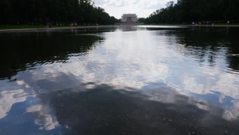 Blick-Vom-Wasser-Auf-Die-Vorderstufen-Des-Lincoln-Memorial,-Aufgenommen-Vom-Reflexionsteich-Mit-Menschen-Im-Vordergrund