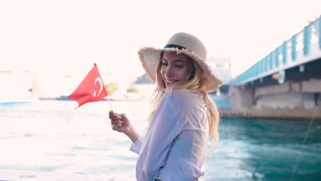 Schönes-Mädchen-Schwenkt-Türkische-Flagge-über-Der-Galata-Brücke-Und-Genießt-Den-Blick-Auf-Den-Bosporus-In-Istanbul,-Türkei