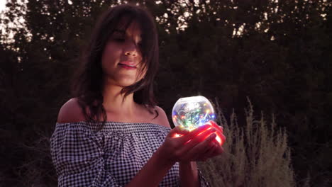 A-beautiful-mysterious-woman-on-a-quest-with-a-magic-glowing-crystal-ball-in-an-enchanting-fantasy-land
