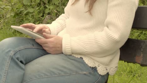 Woman-using-laptop-on-park-bench