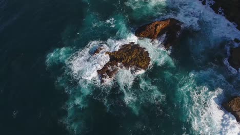 Waves-crashing-on-rocks-in-blue-ocean