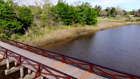 Aerial-video-of-a-wooden-bridge-in-a-stream-on-a-sunny-day