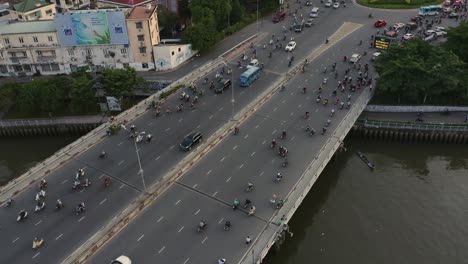 Rising-Crane-shot-of-evening-traffic-over-Dien-Bien-Phu-Bridge,-Binh-Thanh-district,-Ho-Chi-Minh-City,-Vietnam-which-crosses-the-Hoang-Sa-canal