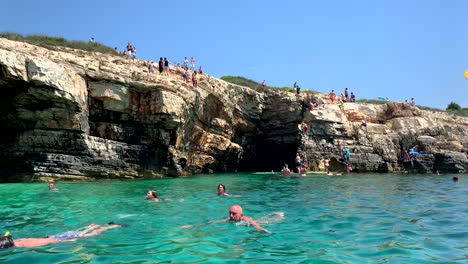 People-jump-from-the-cliff-into-the-clear-water-in-Istria-Croatia