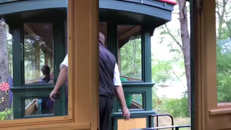 A-train-conductor-checking-tickets-and-crossing-over-to-the-next-train-at-Thomas-Land-and-Edaville-Family-Theme-Park-in-Massachusetts