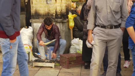 Joven-Vendedor-Ambulante-Vendiendo-Mazorcas-De-Maíz-Fuera-Del-Bazar-Tajrish-En-Teherán,-Irán