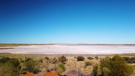 Drohne-Enthüllt-Riesigen-Ausgetrockneten-Salzsee,-Nachdem-Sie-über-Einen-Abgelegenen-Roten-Feldweg-Im-Australischen-Outback-Geflogen-Ist