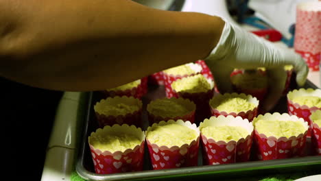 Beating-cupcakes-against-baking-sheet-to-get-air-bubbles-out-of-the-batter