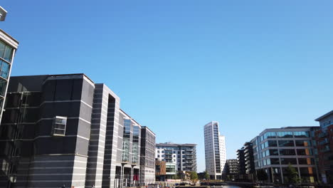 Shot-of-Leeds-Dock-Mixed-Development-in-Yorkshire,-UK-on-a-Sunny-Summer’s-Day-Fading-Out-Diagonally-Left-to-Blue-Sky-in-Slow-Motion