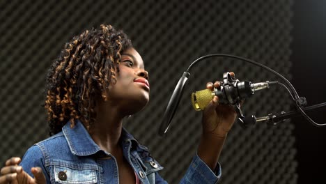 Afroamerikanerin-Mit-Alfro-Haaren,-Schwarze-Frau,-Singt-Laut-Ein-Lied-Und-Drückt-Das-Gefühl-Mit-Power-Sound-über-Hängendem-Mikrofonkondensator-Aus