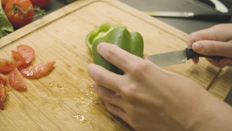 Green-fresh-paprika-is-being-prepared-on-a-wooden-board-for-eating