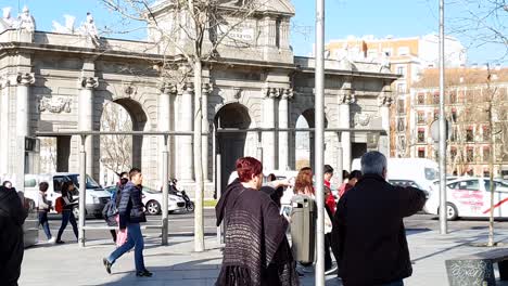 Pedestrians-and-traffic-in-front-of-Puerta-de-Alcála,-Madrid,-Spain