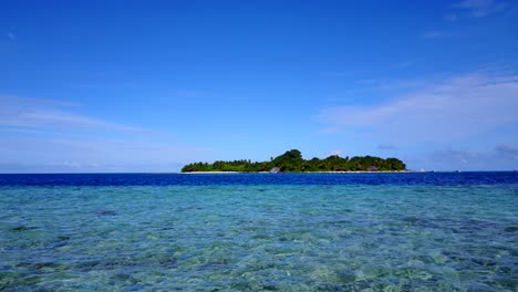 Una-Isla-En-Fiji---Aguas-Claras-Y-Poco-Profundas-Del-Océano-Con-Una-Isla-Exuberante-En-El-Fondo---Toma-Amplia