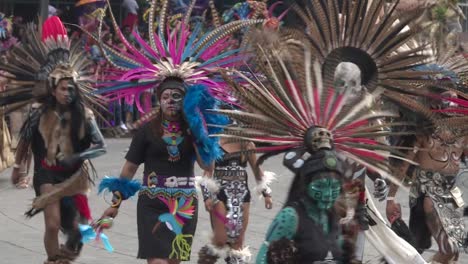 medium-shot,-painted-dancers-and-pre-hispanic-characters-performing-during-day-of-the-dead-parade-in-Mexico-city