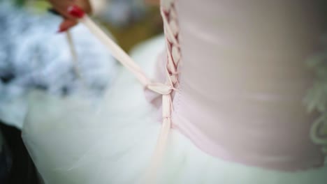 Frauenhände-Schnüren-Hochzeitskleid