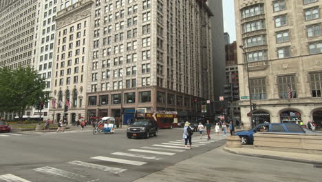 Editorial,-Chicago-street-corner-view,-smooth-zoom-in,-people-crossing,-cars,-traffic,-big-red-bus-tour-for-tourists,-buildings,-city,-urban,-the-loop-area-downtown-Chicago