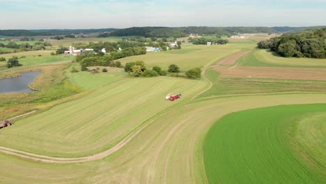 4K-aerial-view-of-a-harvester-harvesting-hay-in-the-distance