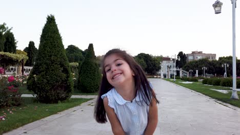 Little-funny-girls-runs-towards-camera-and-makes-funny-things-in-the-park