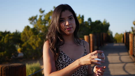 A-pretty-hispanic-woman-with-a-magic-crystal-ball-smiling-and-acting-cute-in-slow-motion-at-sunset