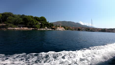 Entering-with-a-boat-into-Cavtat-town-near-Dubrovnik-on-a-Croatian-coast-on-a-sunny-summer-day