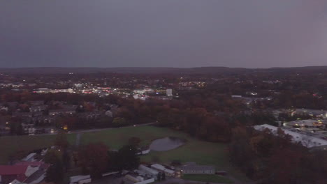 Rising-drone-time-lapse-shot-at-sunset-in-a-small-town