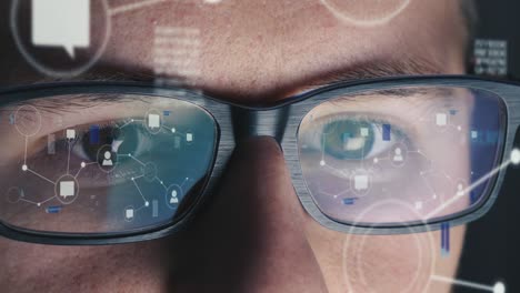 Man-with-glasses-works-on-a-global-network-at-computer-screen---Screen-reflected-on-his-glasses---Close-up