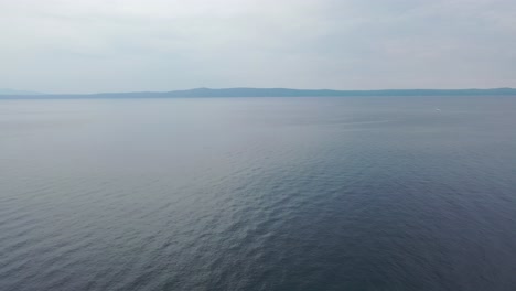 Aerial-video-of-calming-water-of-the-Adriatic-Sea-during-a-warm-sunny-morning-with-a-blue-cloudless-sky