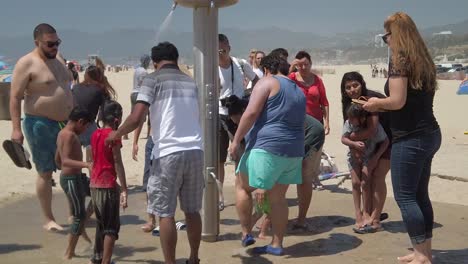 People-washing-themselves-off-on-the-beach-in-Santa-Monica,-California-in-slow-motion