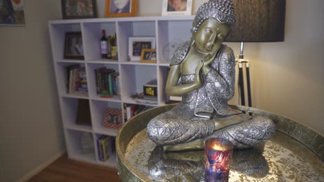 Buddha-Figur-Vor-Leuchtender-Kerze-Im-Wohnzimmer,-Arbeitszimmer,-Beruhigend