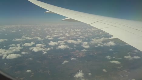 An-accelerate-shot-taken-from-a-window-in-a-plane-of-the-wing-and-many-tiny-clouds