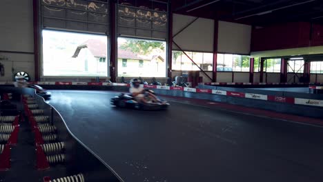 Close-up-follow-movement-of-Go-karts-racing-indoor-on-a-sunny-day