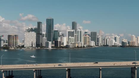 Wide-aerial-drone-flying-over-bridge---water-towards-downtown-Miami-4k