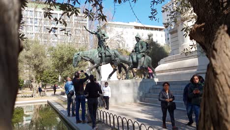 Tourists-taking-photos-of-famous-Bronze-sculptures,-Statue-of-Quixote-and-Sancho-on-the-Square-of-Spain-in-Madrid