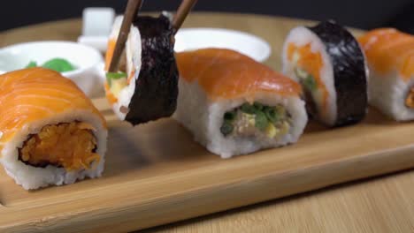 Ein-Stück-Sushi-Mit-Stäbchen-Von-Einem-Servierbrett-Nehmen