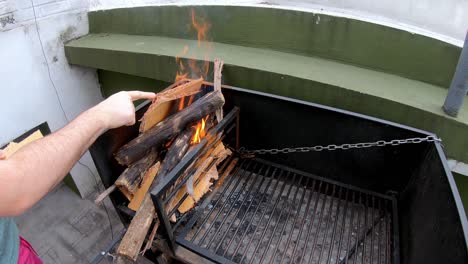 Slow-motion-video-of-a-white-man-lighting-the-fire-with-paperboard-to-grill-on-a-sunny-day