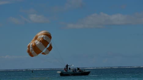 A-shot-following-from-the-shore-of-a-sport-boat-that´s-going-to-start-to-do-parasailing,-until-the-moment-of-take-off