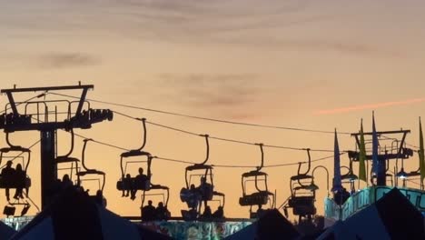 Setting-sun-silhouettes-the-sky-tram-ride-at-the-North-Carolina-State-Fair-in-Raleigh,-NC,-2019