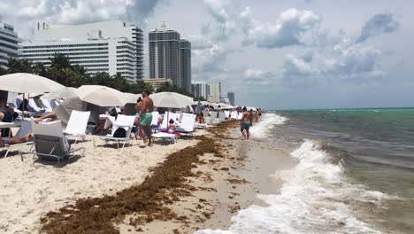 A-variety-of-people-enjoying-the-warm-sun,-soft-sand-and-surf-on-Miami-Beach,-Miami,-Florida