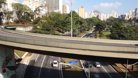 Vehículos-Que-Viajan-En-Un-Viaducto-Sobre-La-&#39;avenida-23-De-Maio&#39;-Y-El-Paisaje-Urbano-Al-Fondo