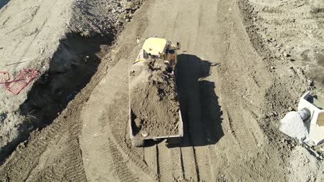 Aerial-view-of-a-dumper-truck-tipping-earth-on-a-large-construction-site-in-the-UK